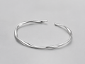VEER Cuff in silver — sculptural twisted open cuff, studio view