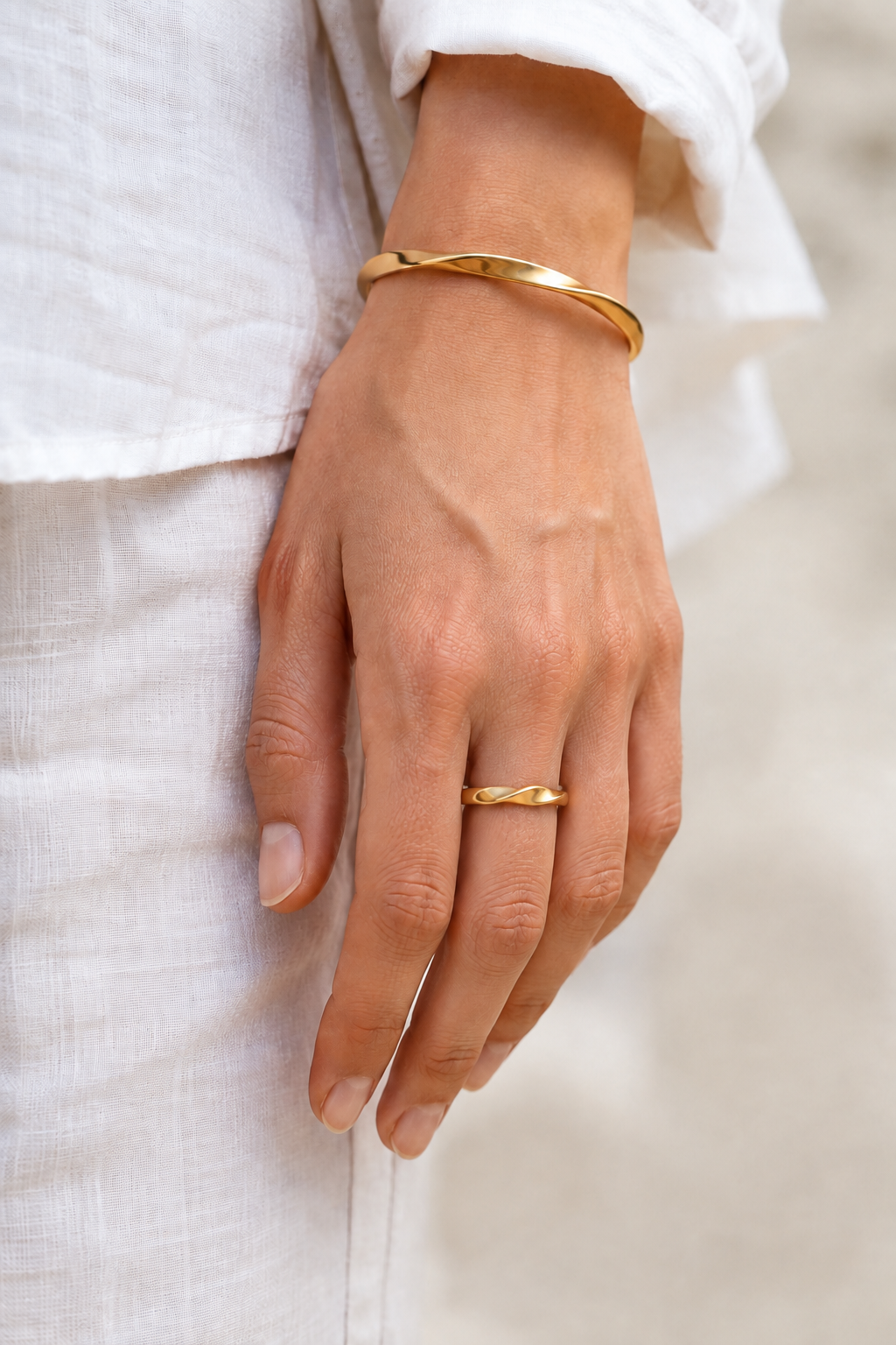 VEER Gold ring styled on a feminine hand with white linen