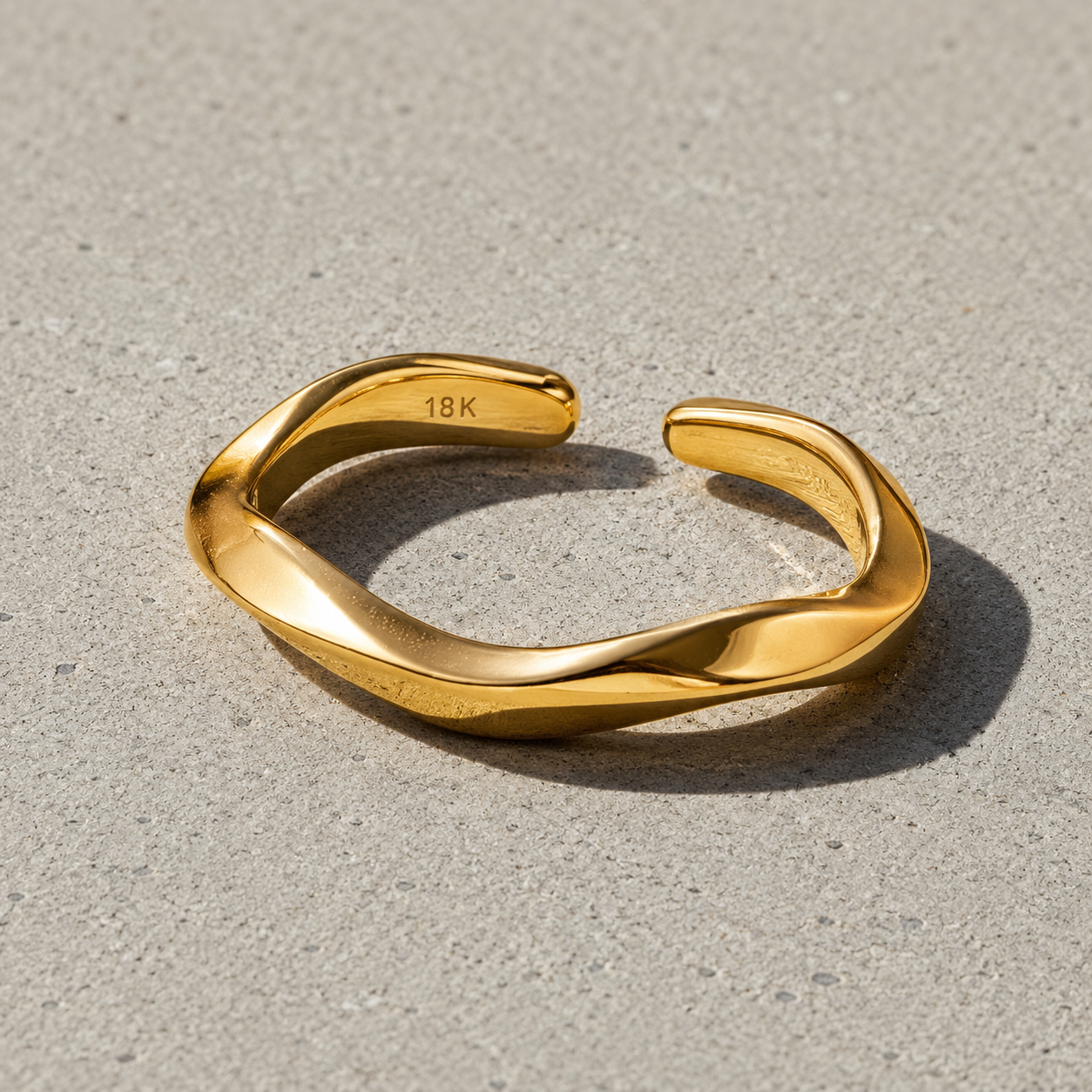 VEER adjustable ring in Gold on a textured stone background