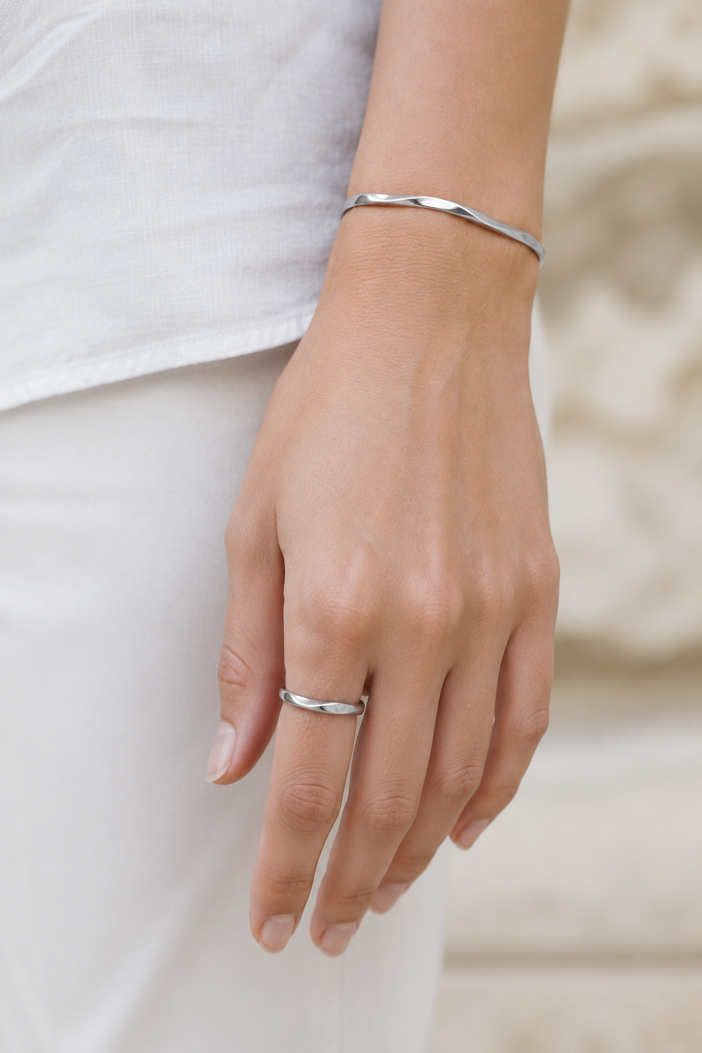 VEER Silver ring styled on a feminine hand with white linen